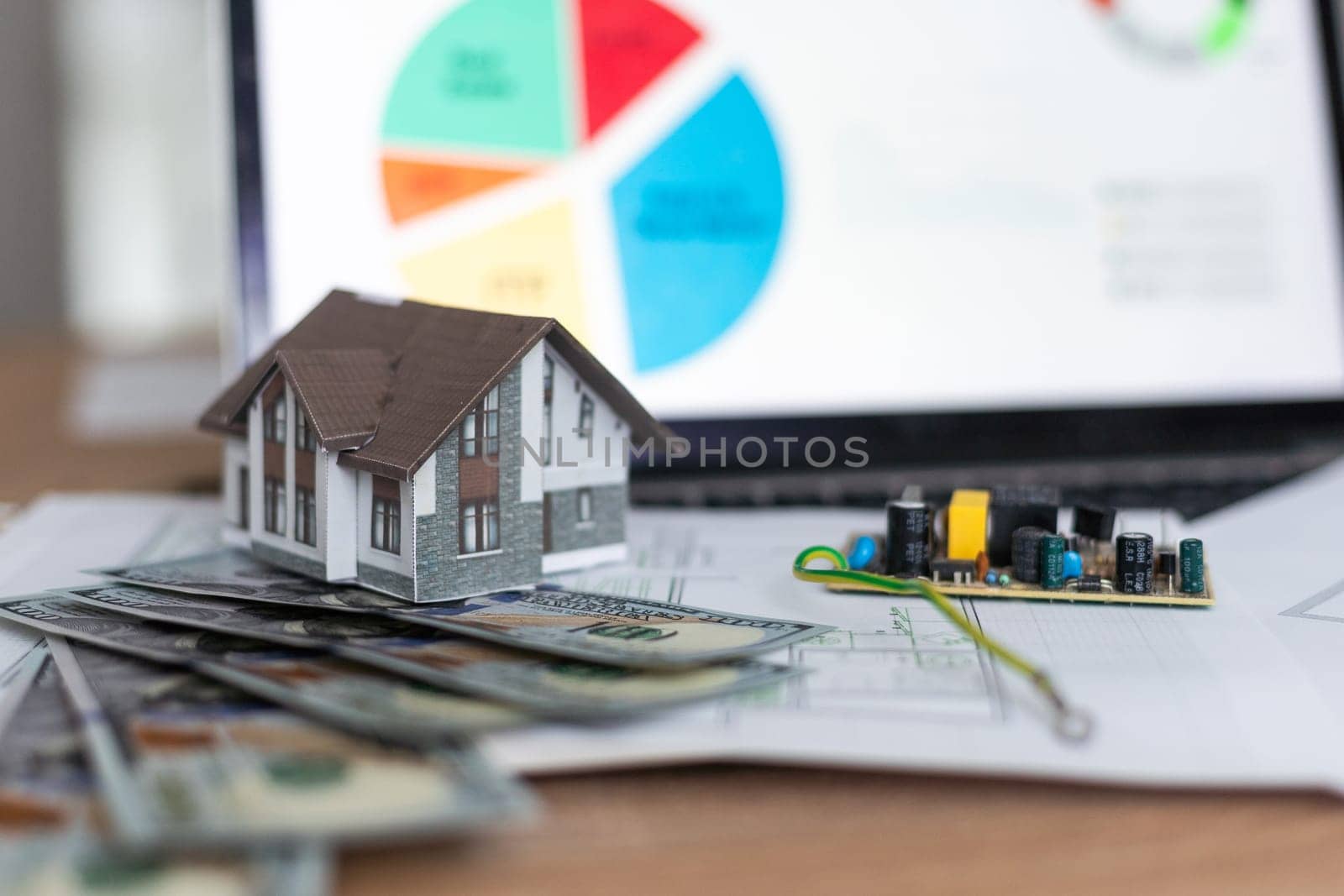 Model house on top of money pile suggesting savings for a house. High quality photo