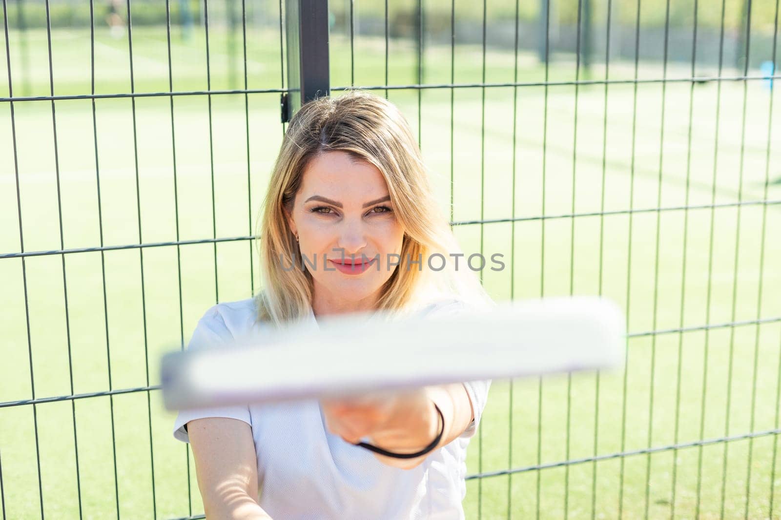 Sportive young girl with racquet playing padel in court. High quality photo