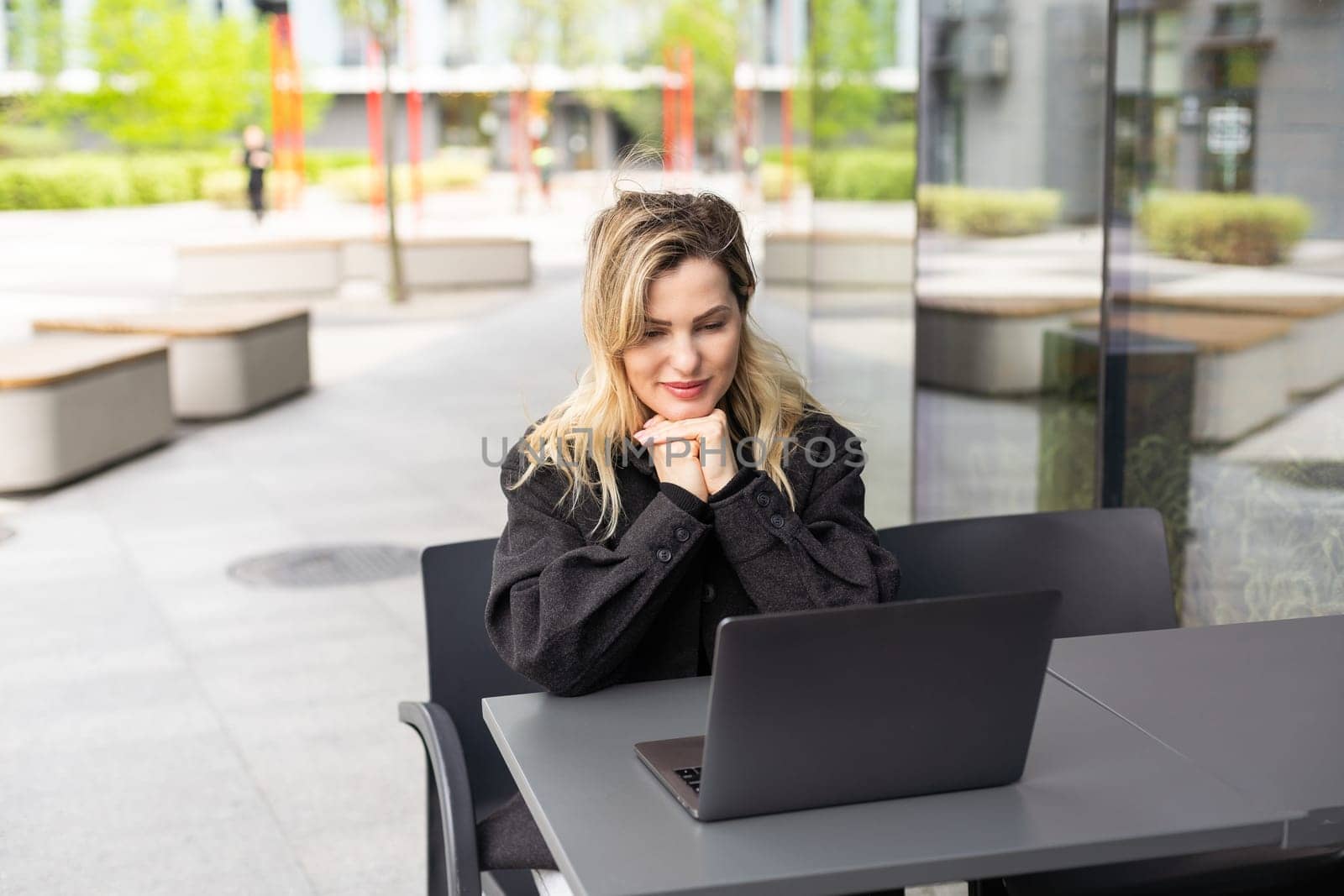 Young woman with laptop outside. High quality photo