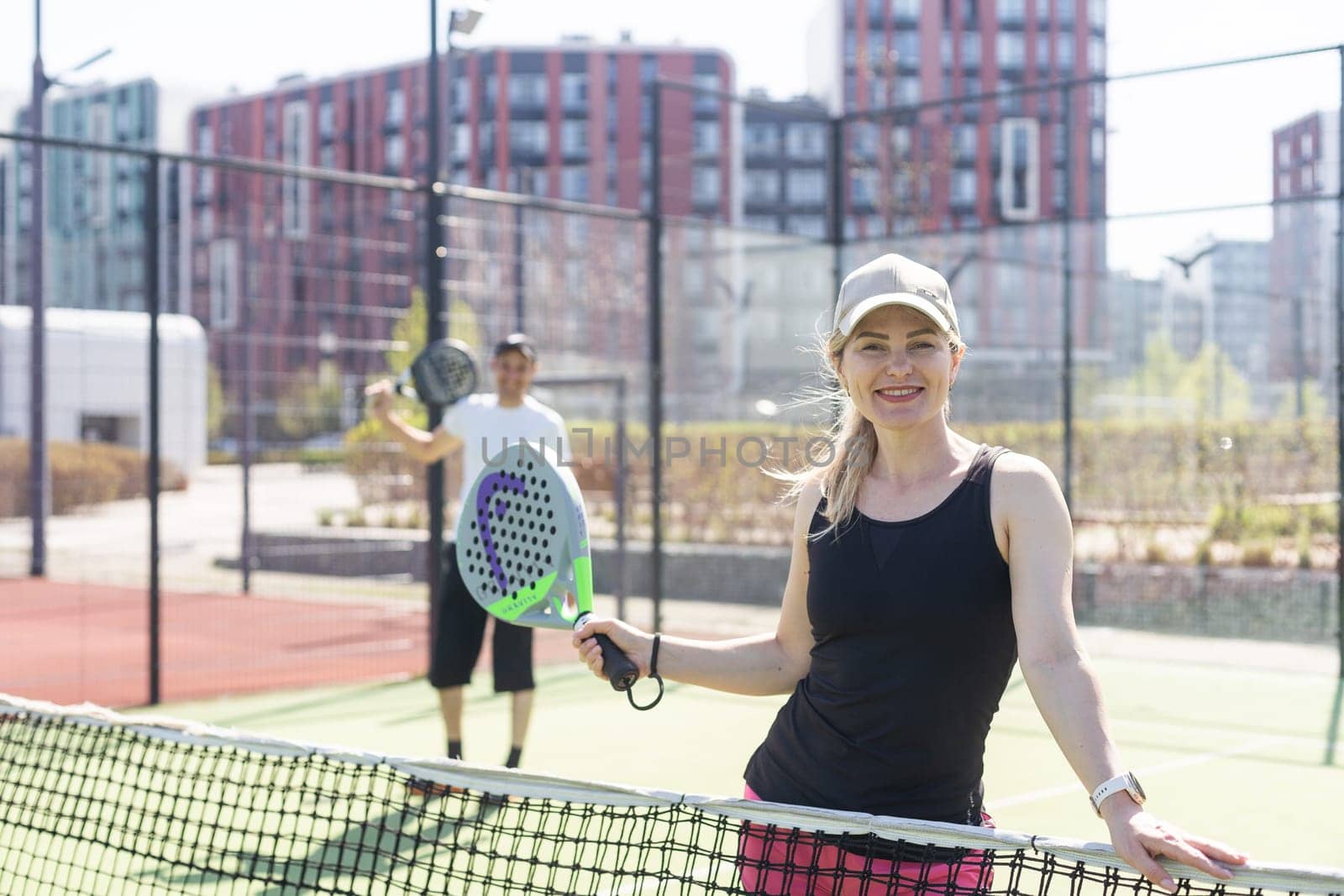 Ukraine Kyiv, April 02 2024. Happy athletic couple having fun while playing padel tennis doubles match on outdoor court. . High quality photo