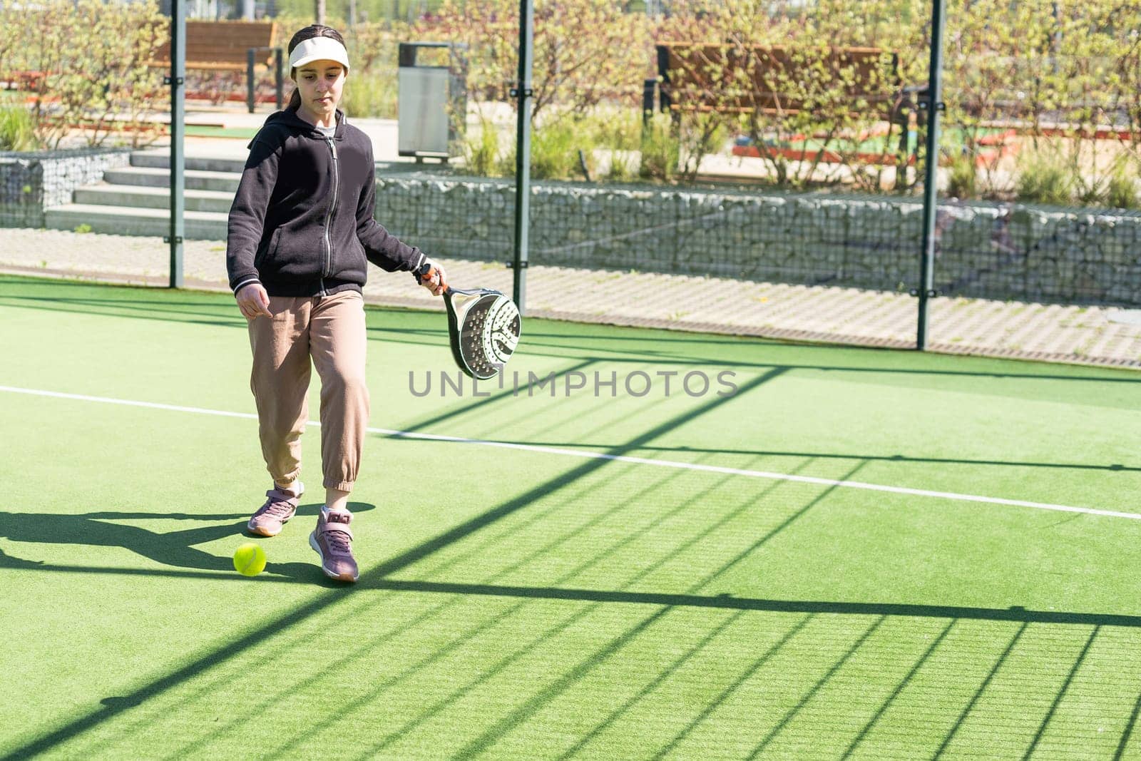 little girl playing padel and hitting the ball with his racket outdoors sports concepts. High quality photo