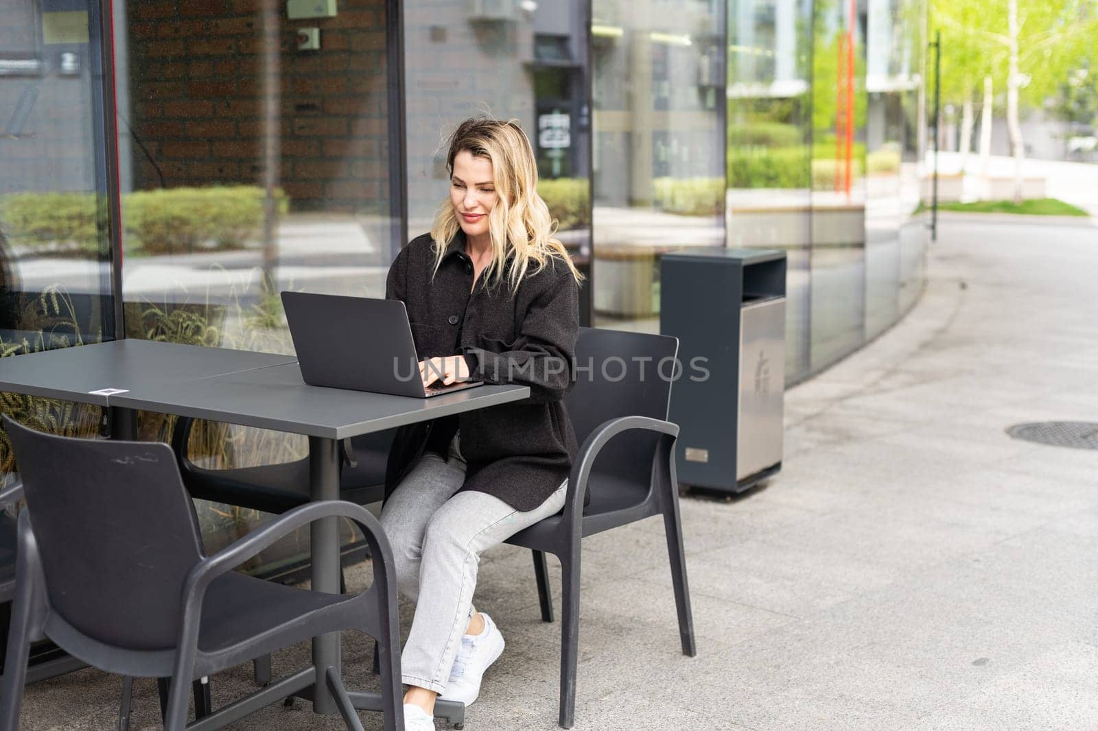 Young woman with laptop outside. High quality photo