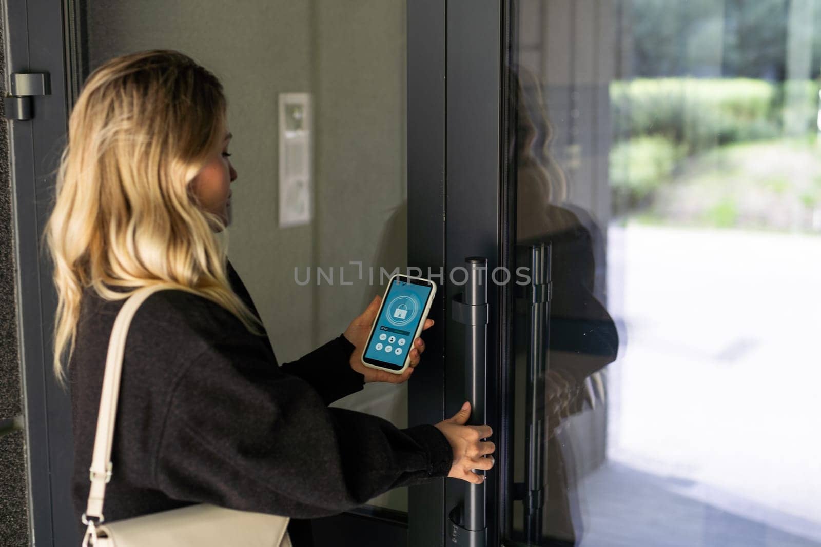 Smiling woman setting home security system with help of mobile application. High quality photo