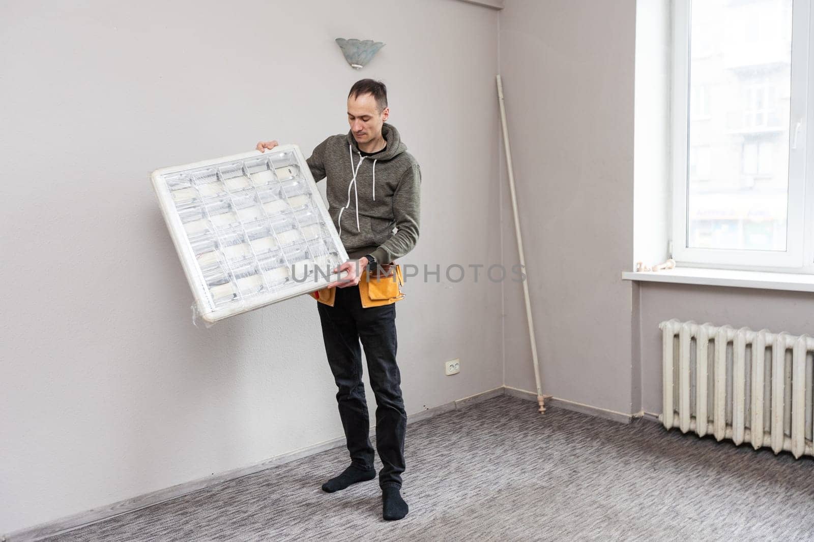 Maintenance man changing light bulbs in office. High quality photo