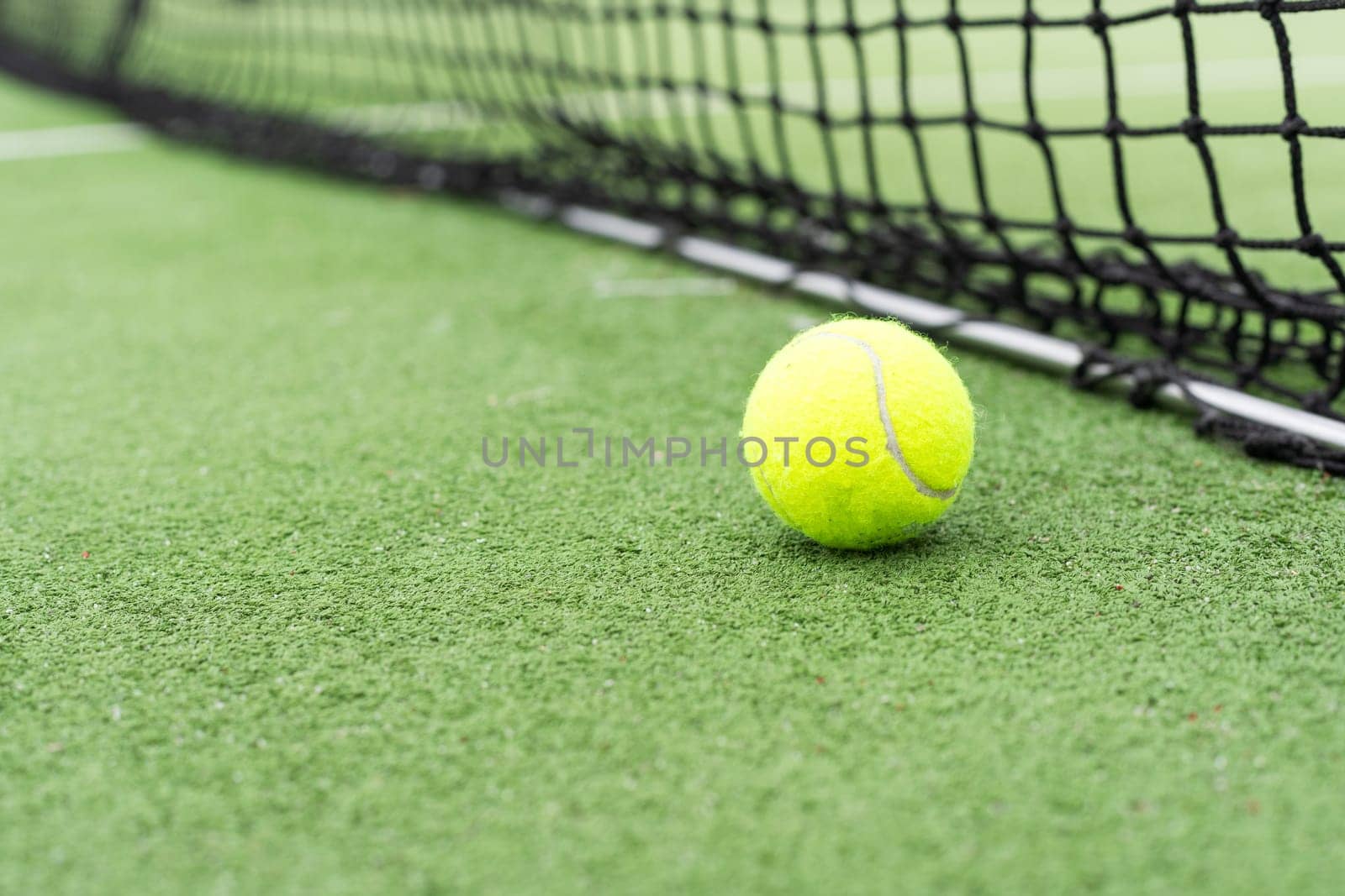 Tennis Ball on the Court against the Court Net. High quality photo