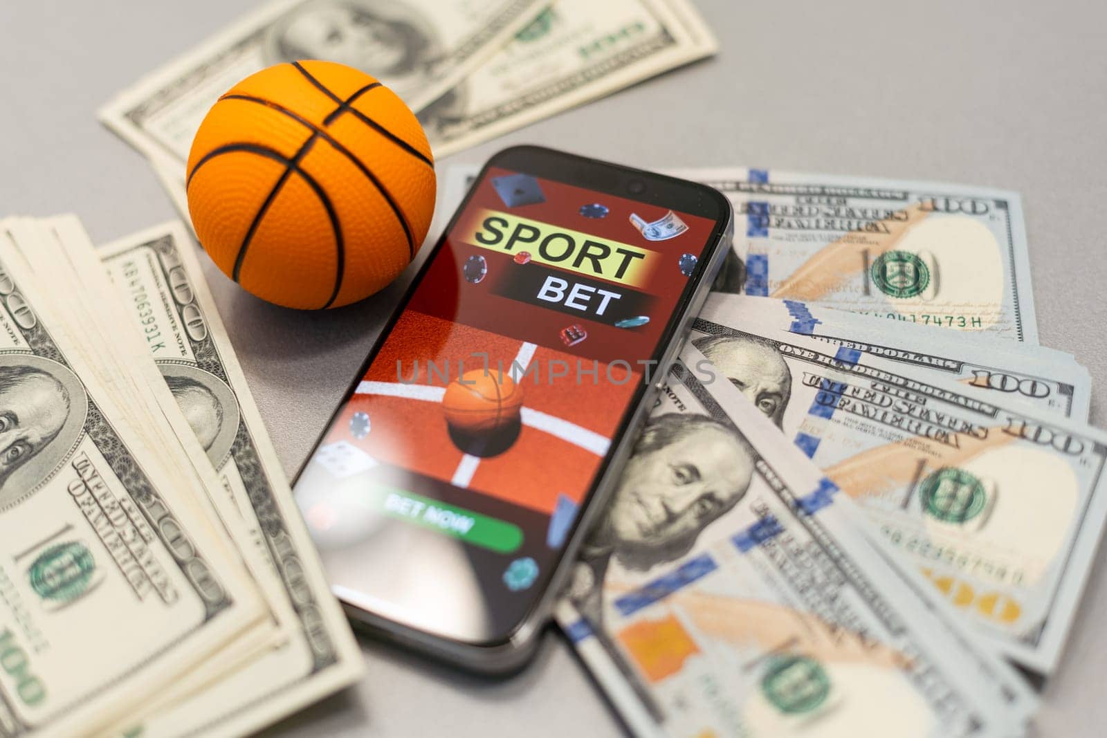 Sports betting website in a mobile phone screen, ball, money. High quality photo