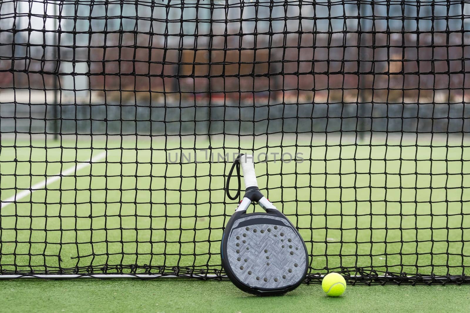 White professional paddle tennis racket with natural lighting on blue background. Horizontal sport theme poster, greeting cards, headers, website and app. High quality photo