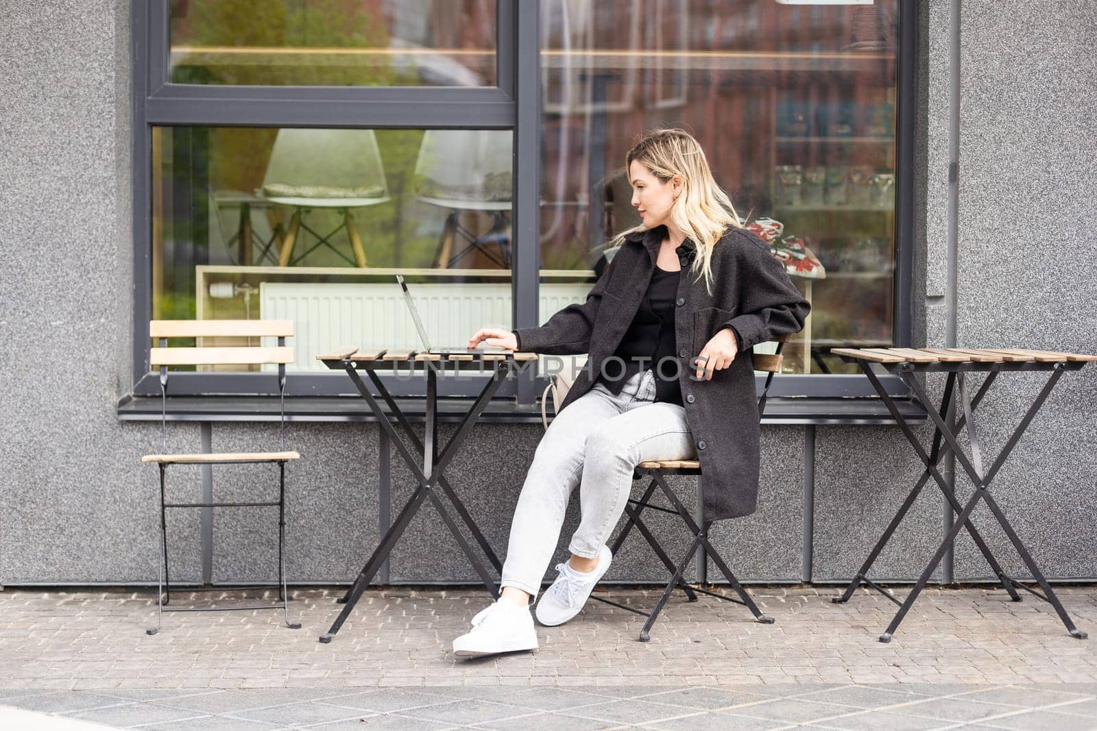 Businesswoman working with laptop in outdoor cafe. Corporate blog. High quality photo