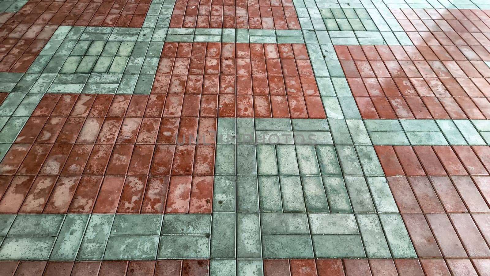 Multicolored red and gray tiles on the floor in rows and patterns. Background, texture, pattern and place for text