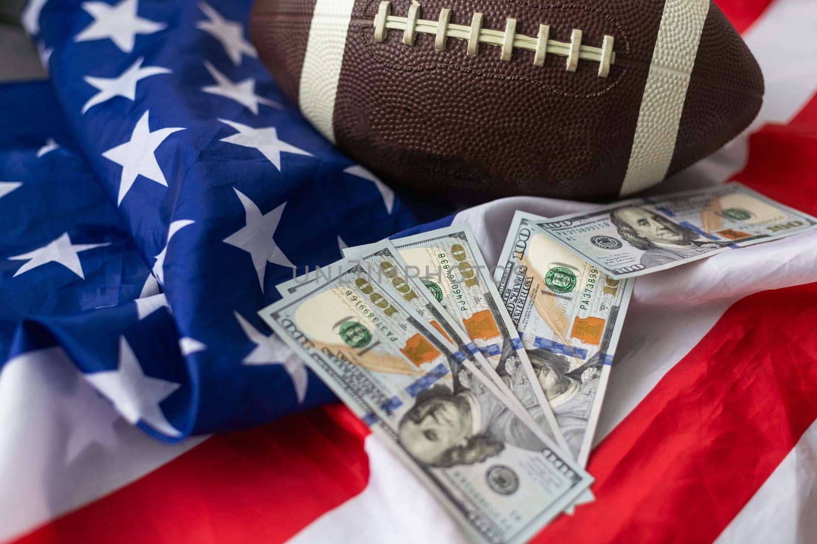 Money and rugby ball on american flag background, closeup. Concept of sports bet. High quality photo