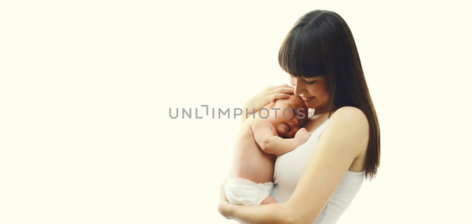 Happy young mother holding cute infant, baby sleeping in arms on white studio background