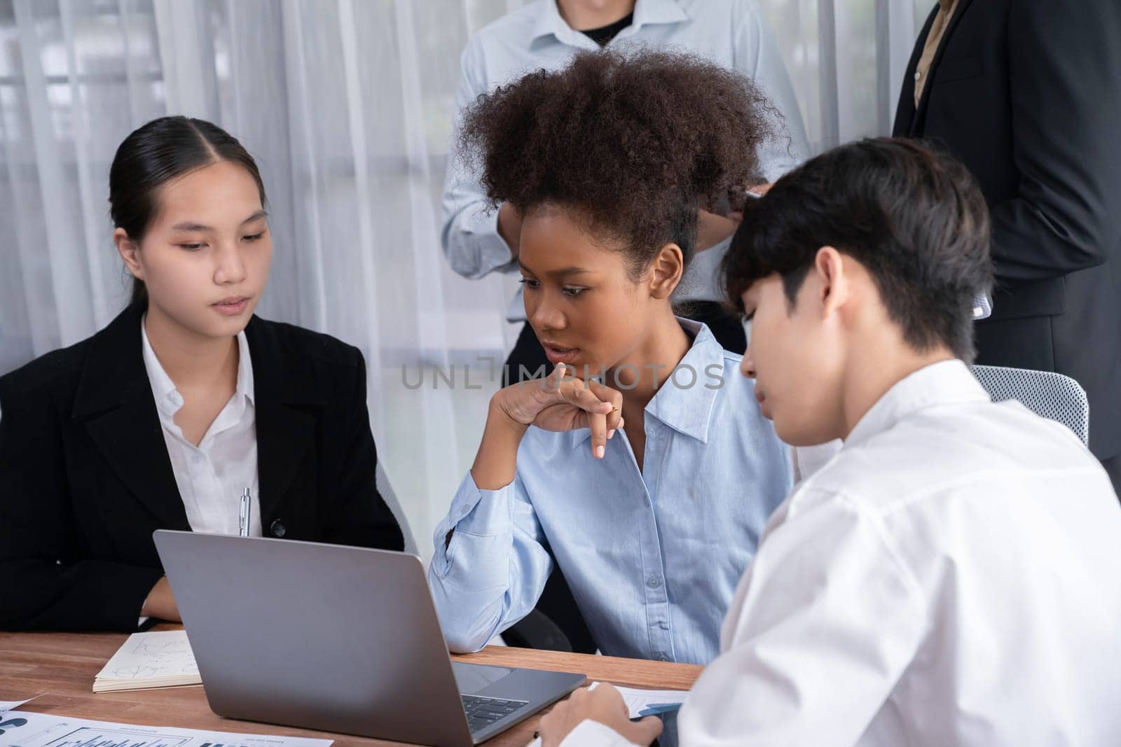 Happy diverse business people work together, discussing in corporate office. Professional and diversity teamwork discuss business plan on desk with laptop. Modern multicultural office worker. Concord