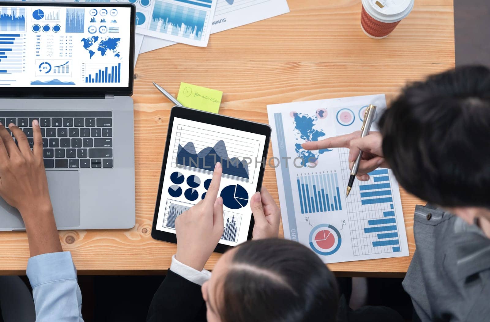 Multiracial analyst team use BI Fintech software to analyze financial data on meeting. Top view finance dashboard data display on laptop screen with analyzed chart for marketing indication. Concord