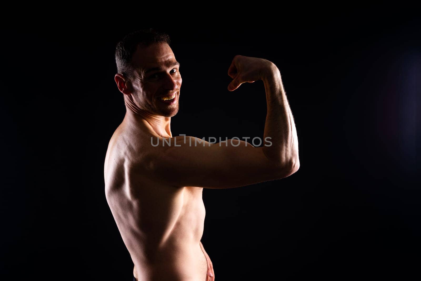 Portrait of man, bodybuilder and bicep flex in studio, background and exercise for muscular power. by Zelenin