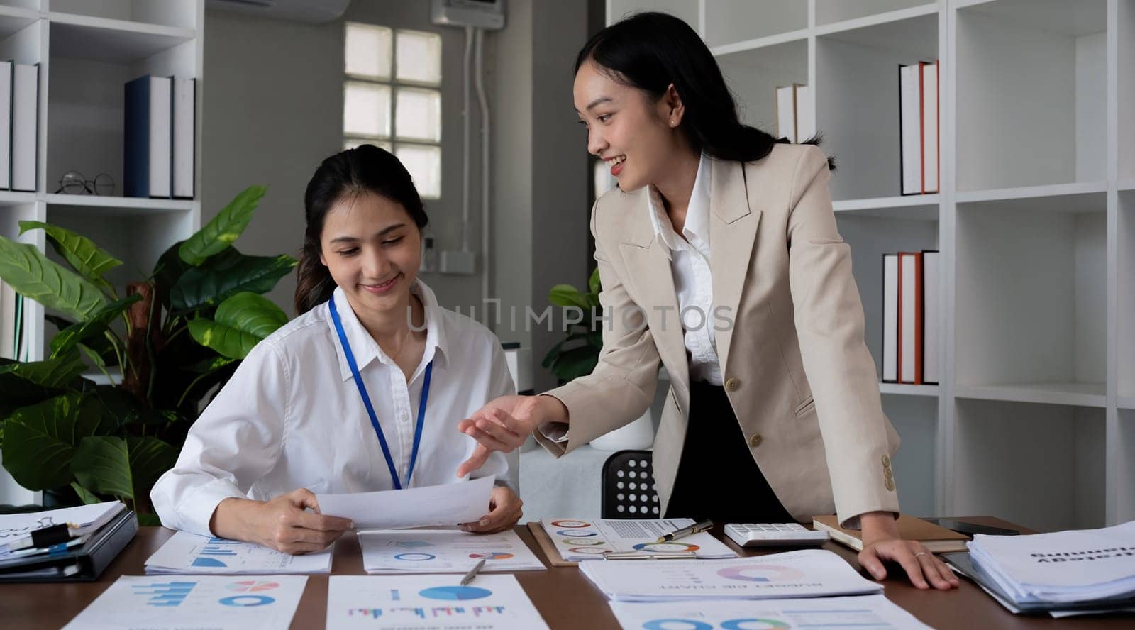 Team businesswomen discussing financial reports in office.