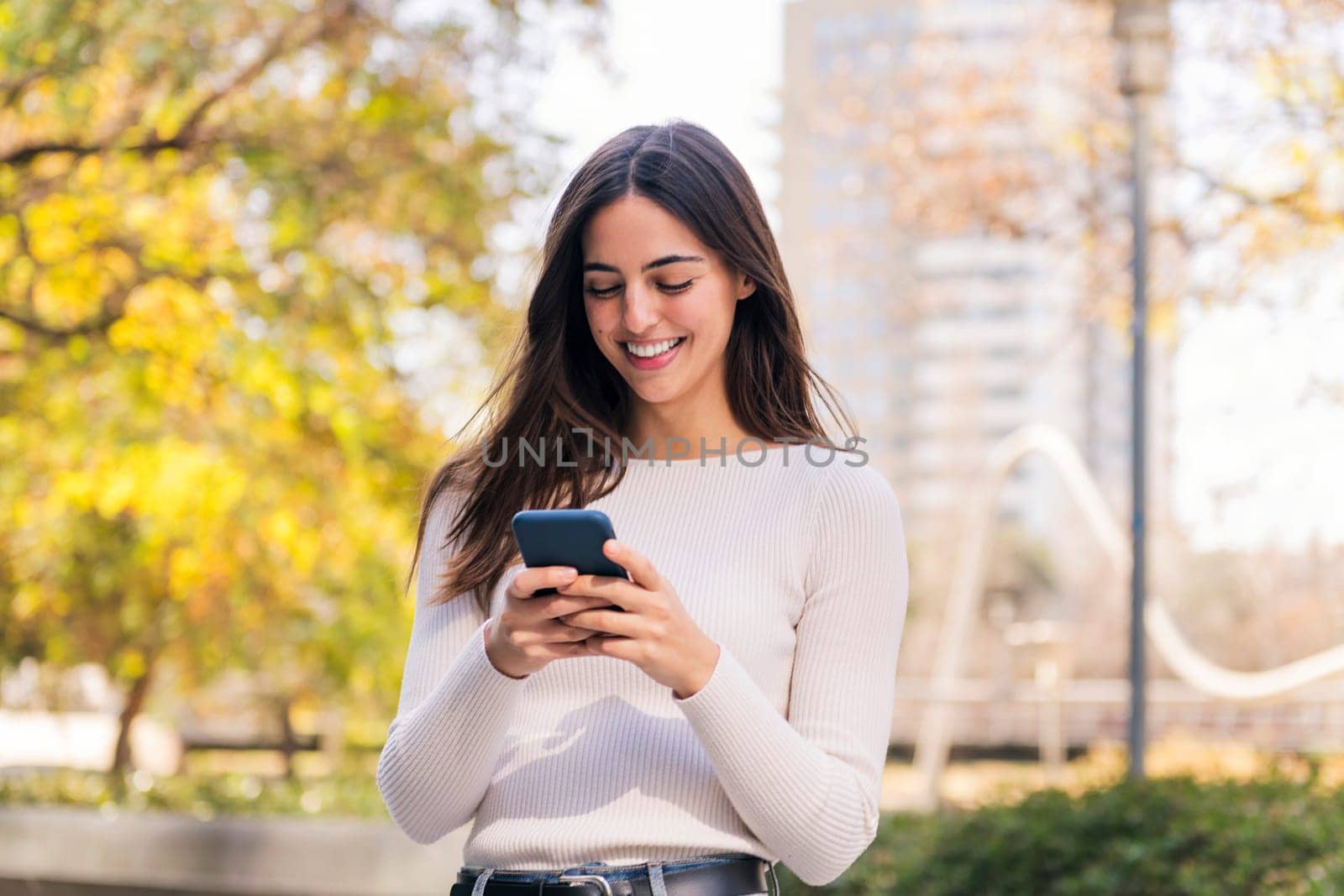 caucasian woman smiling happy using her mobile phone, concept of technology of communication and modern lifestyle, copy space for text