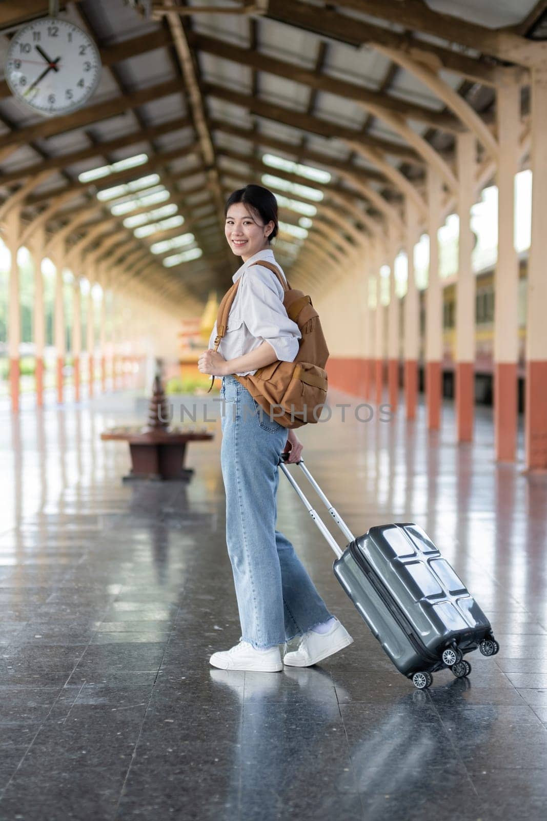 Young Asian woman waiting for train at train station to travel.