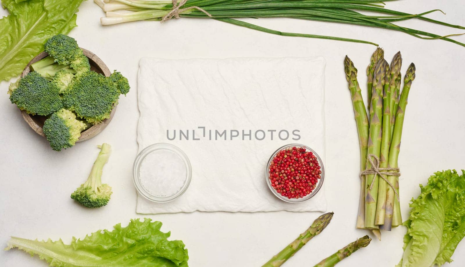 Raw asparagus, broccoli and spices on white background, top view