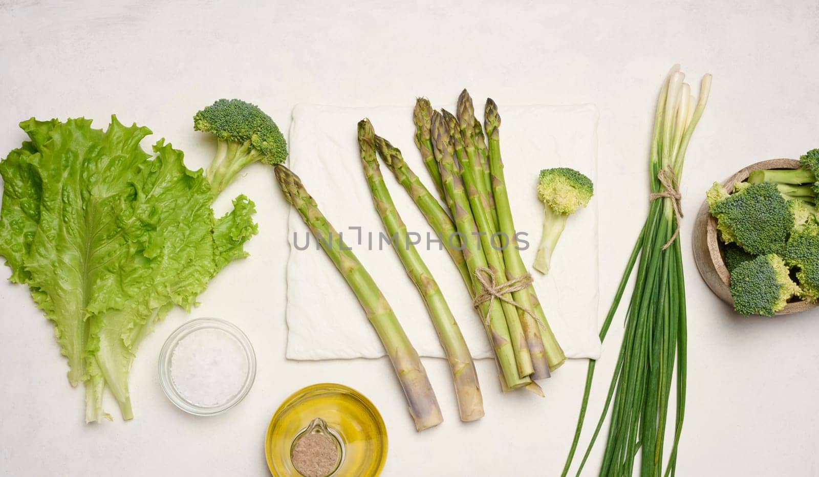 Raw asparagus, broccoli and spices on white background, top view.  by ndanko