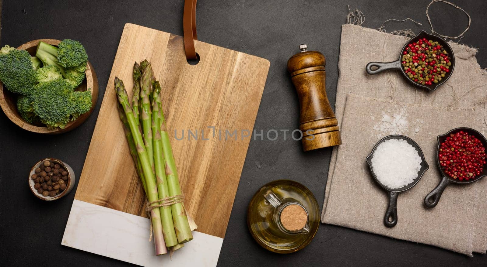 Fresh green asparagus sprouts on a black wooden background. View from above by ndanko