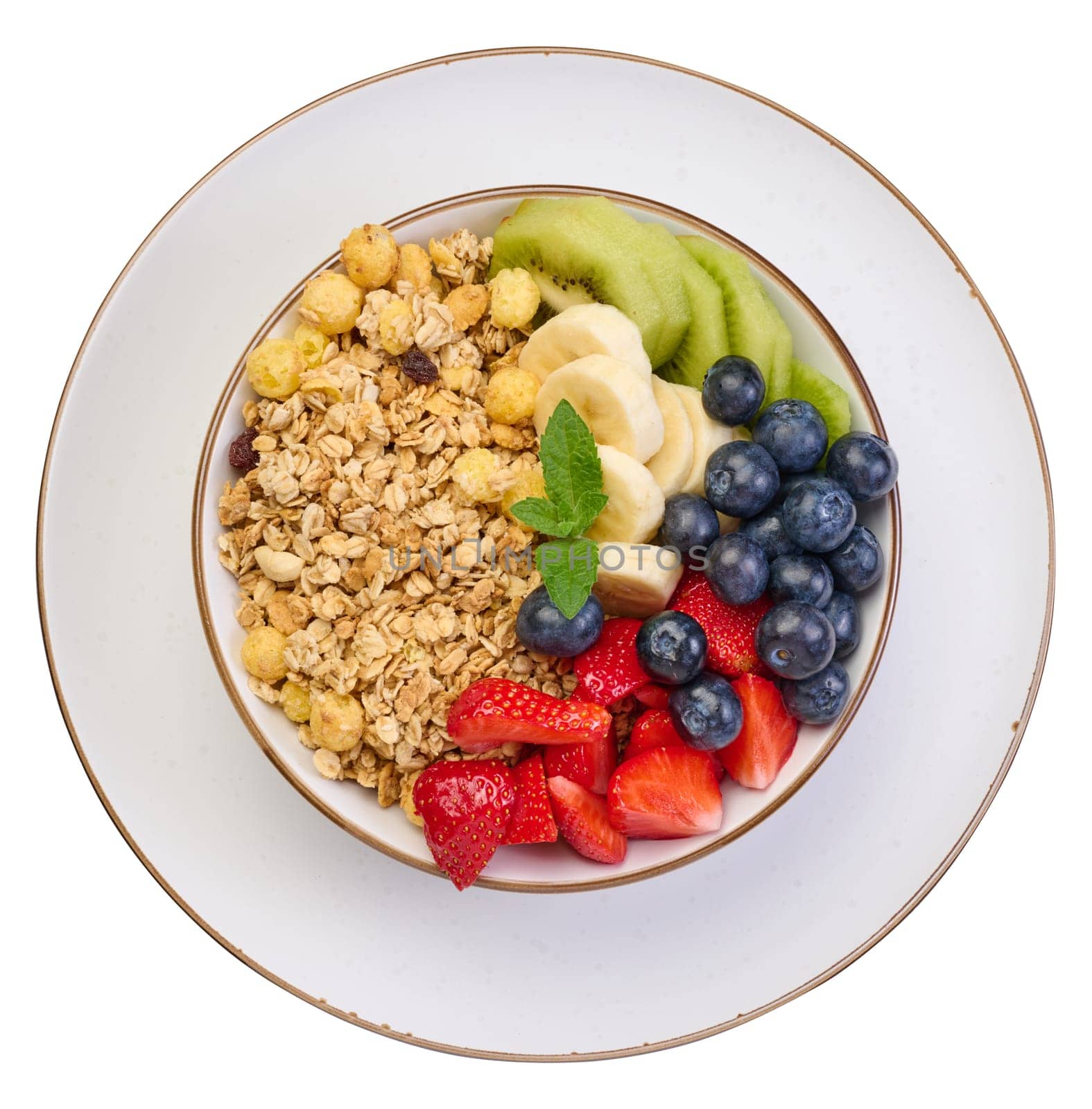 Granola with strawberries, kiwi, banana and blueberries in a white round plate, top view. Isolated background