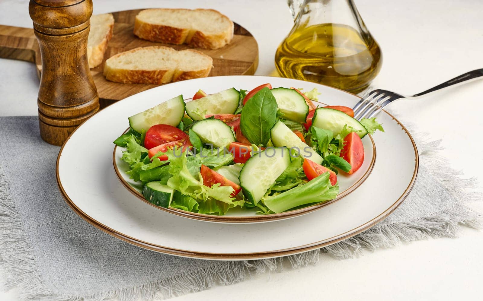 Salad of chopped cherry tomatoes and cucumbers in a white round plate on the table, healthy food