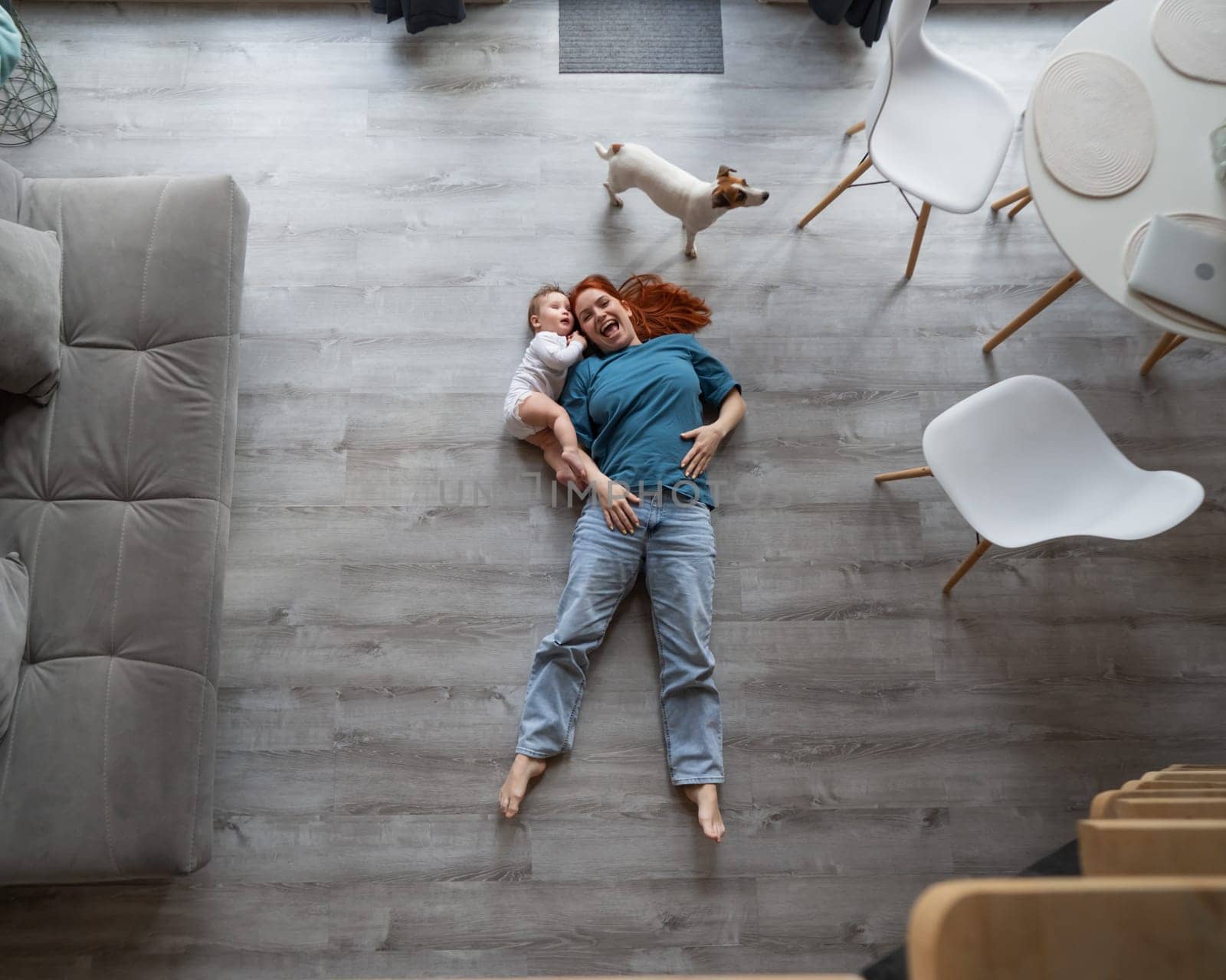 Top view of caucasian woman lying on floor with son and jack russell terrier dog