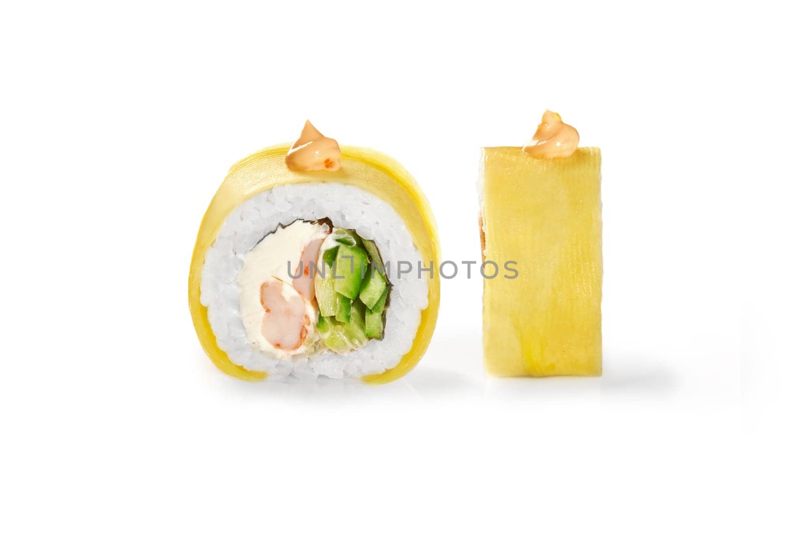 Closeup detailed view of mango-topped sushi roll filled with succulent crab, soft cream cheese, and crisp cucumber, finished with spicy mayo. Japanese style snack