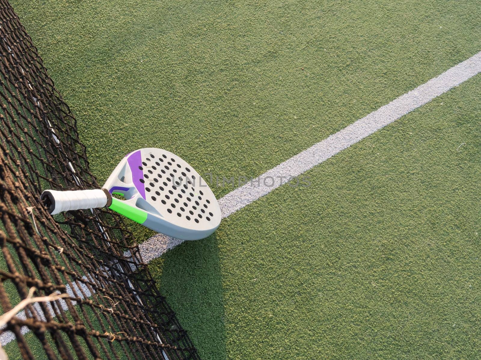 Background of padel racket and ball on artificial grass floor in outdoor court. Top view. High quality photo