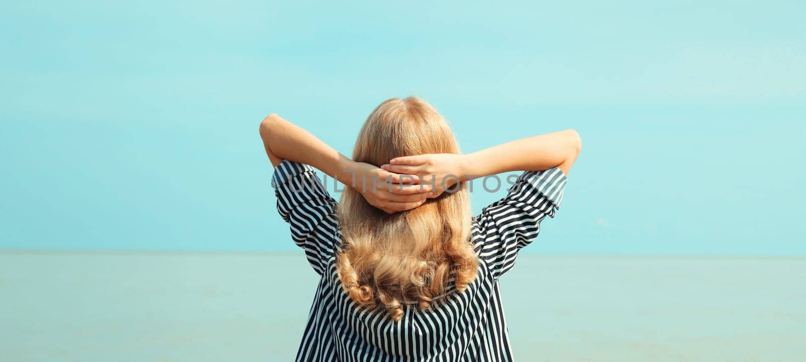 Summer vacation, happy relaxing healthy young woman meditates and enjoying fresh air on the beach on sea coast and blue sky background