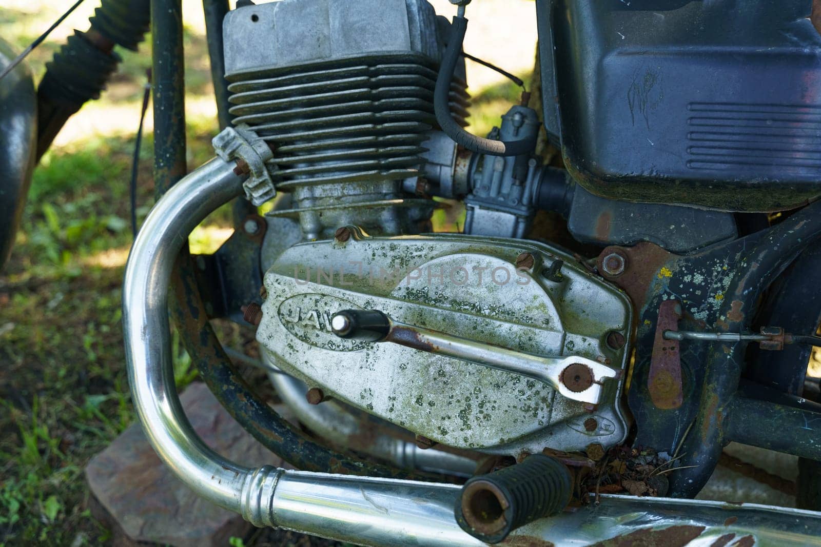 Kretinga, Lithuania - August 12, 2023: Detailed view of the intricate components of an aged motorcycle engine, showing rust, oil residue, and mechanical details.