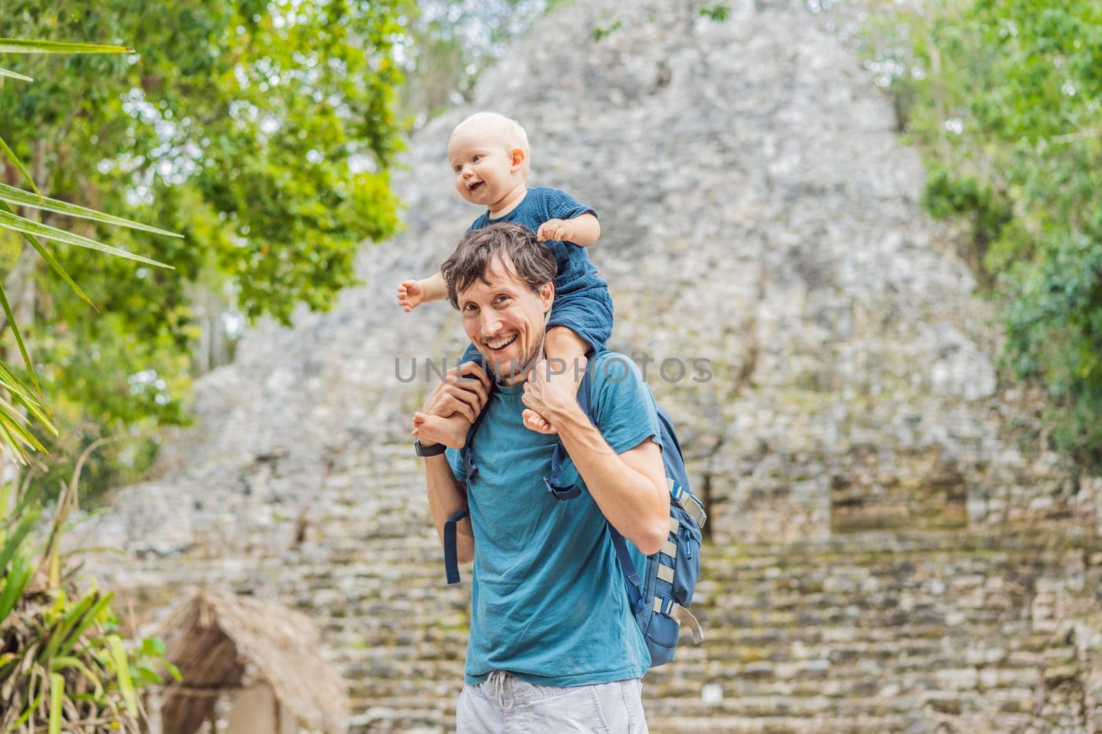 Dad and son tourists at Coba, Mexico. Ancient mayan city in Mexico. Coba is an archaeological area and a famous landmark of Yucatan Peninsula. Cloudy sky over a pyramid in Mexico.