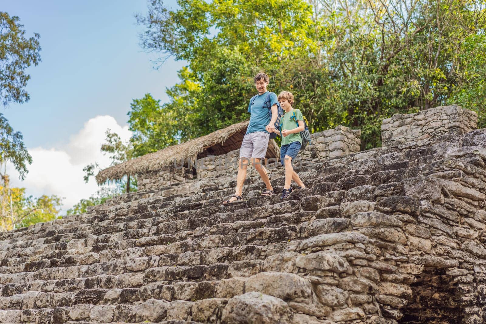 Dad and son tourists at Coba, Mexico. Ancient mayan city in Mexico. Coba is an archaeological area and a famous landmark of Yucatan Peninsula. Cloudy sky over a pyramid in Mexico.