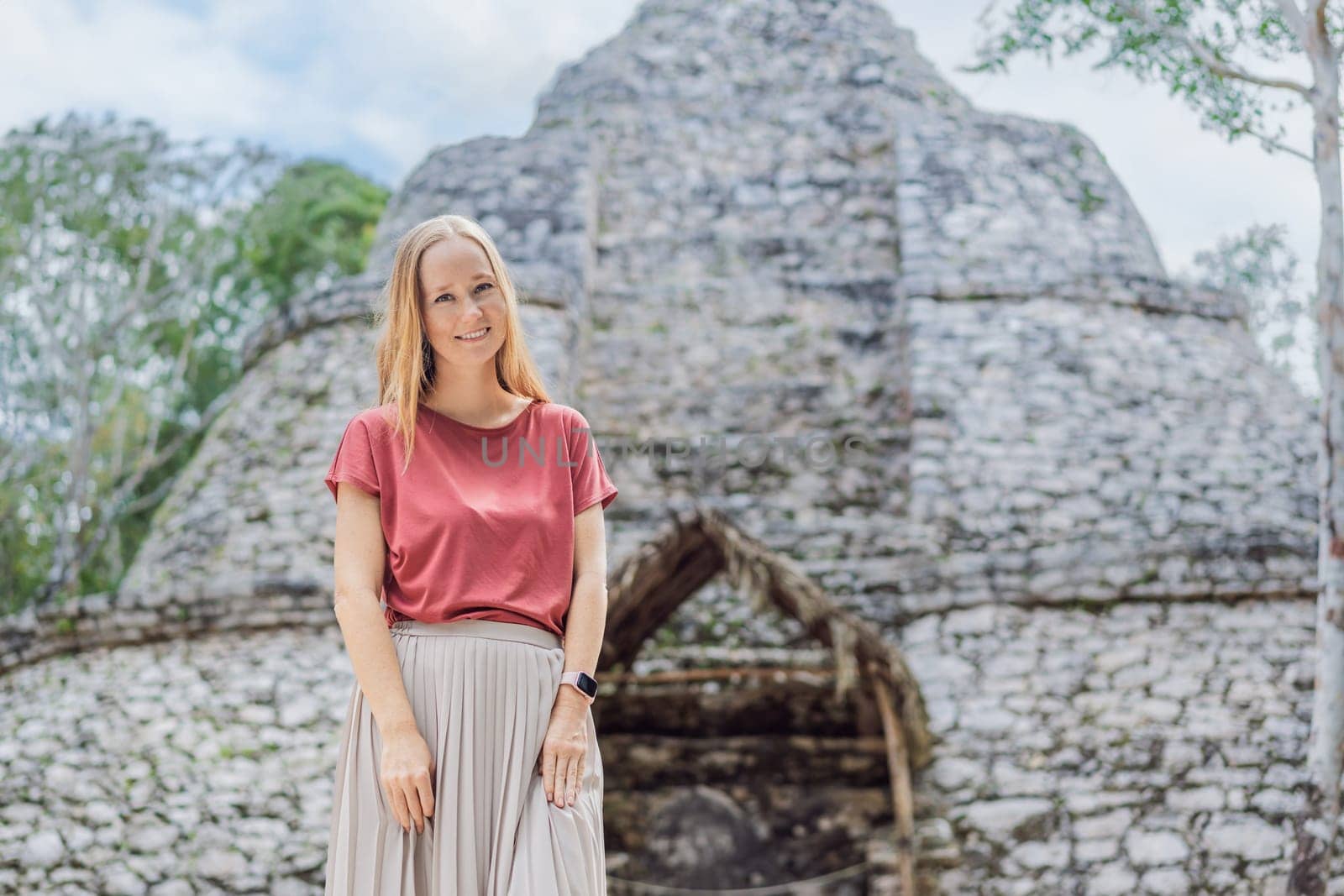 Woman tourist at Coba, Mexico. Ancient mayan city in Mexico. Coba is an archaeological area and a famous landmark of Yucatan Peninsula. Cloudy sky over a pyramid in Mexico.