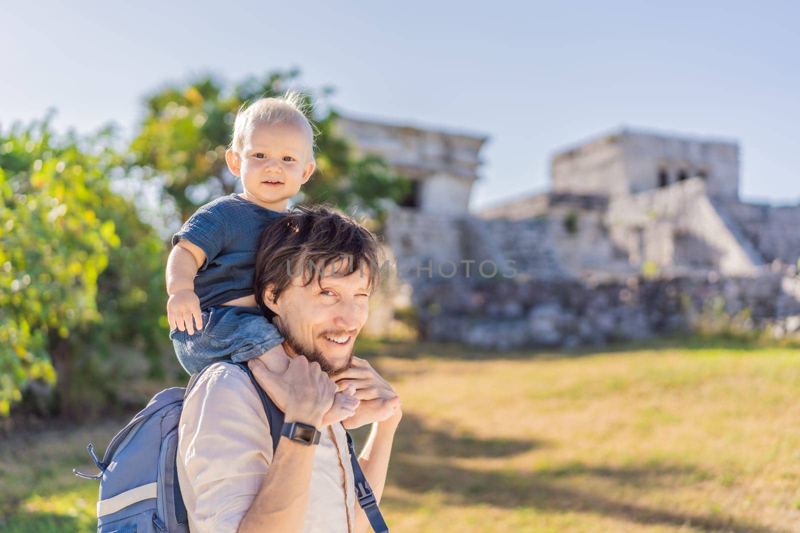 Father and son tourists enjoying the view Pre-Columbian Mayan walled city of Tulum, Quintana Roo, Mexico, North America, Tulum, Mexico. El Castillo - castle the Mayan city of Tulum main temple.