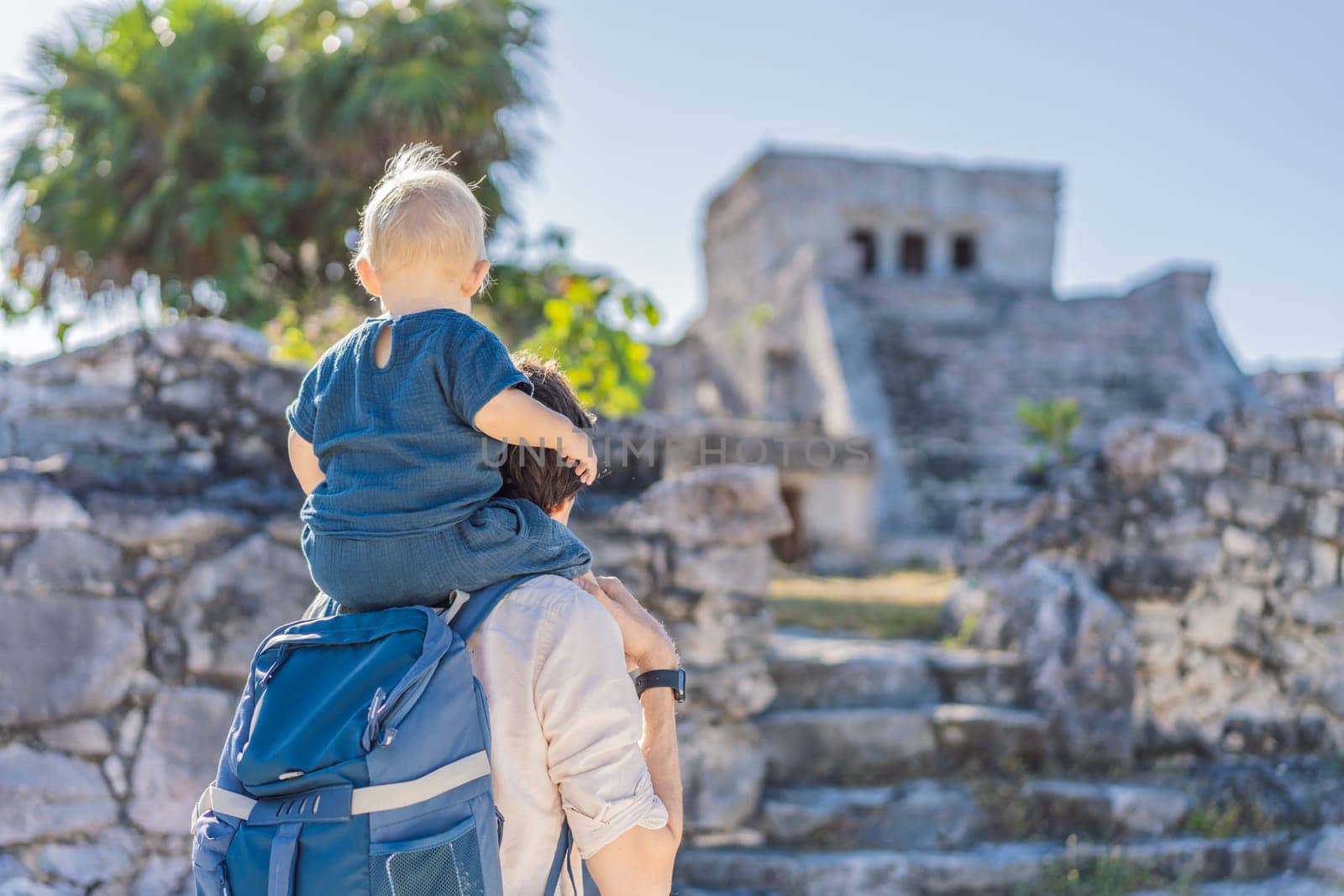 Father and son tourists enjoying the view Pre-Columbian Mayan walled city of Tulum, Quintana Roo, Mexico, North America, Tulum, Mexico. El Castillo - castle the Mayan city of Tulum main temple.