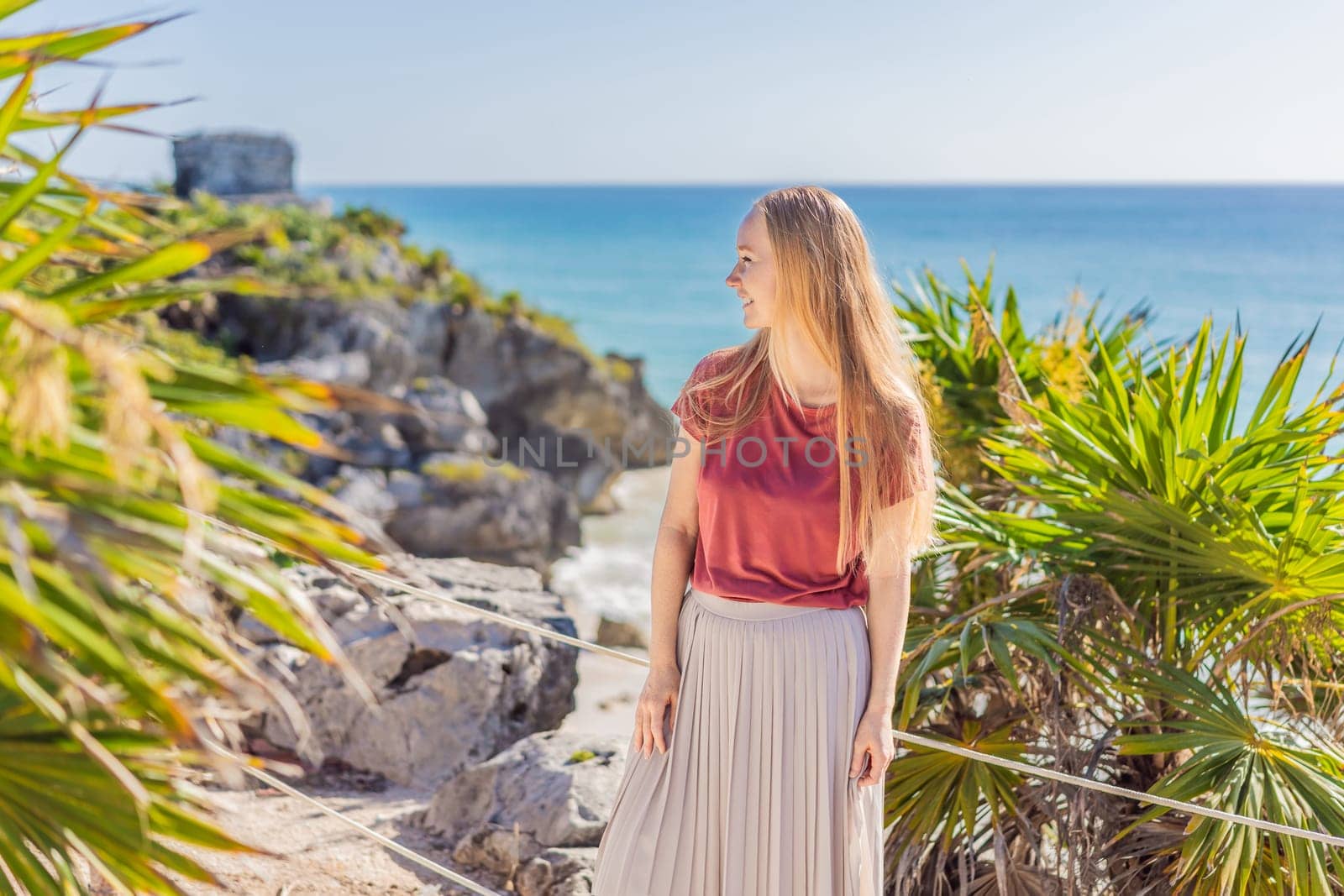 Woman tourist enjoying the view Pre-Columbian Mayan walled city of Tulum, Quintana Roo, Mexico, North America, Tulum, Mexico. El Castillo - castle the Mayan city of Tulum main temple.