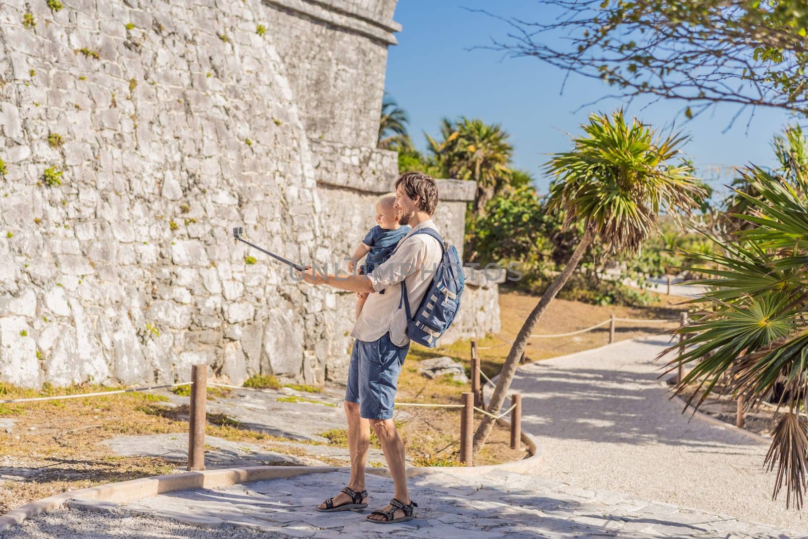 Father and son tourists enjoying the view Pre-Columbian Mayan walled city of Tulum, Quintana Roo, Mexico, North America, Tulum, Mexico. El Castillo - castle the Mayan city of Tulum main temple.