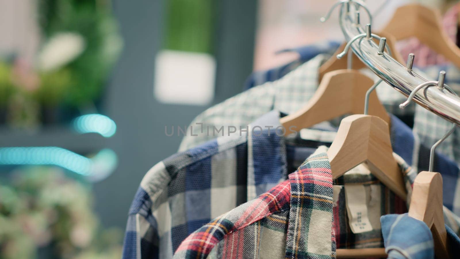 Close up shot on luxury fashion boutique elegant clothes on racks. Zoom out on high class men shirts and other garments on hangers in trendy clothing store in shopping center