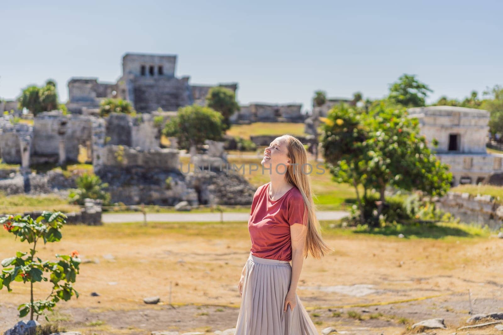 Woman tourist enjoying the view Pre-Columbian Mayan walled city of Tulum, Quintana Roo, Mexico, North America, Tulum, Mexico. El Castillo - castle the Mayan city of Tulum main temple.