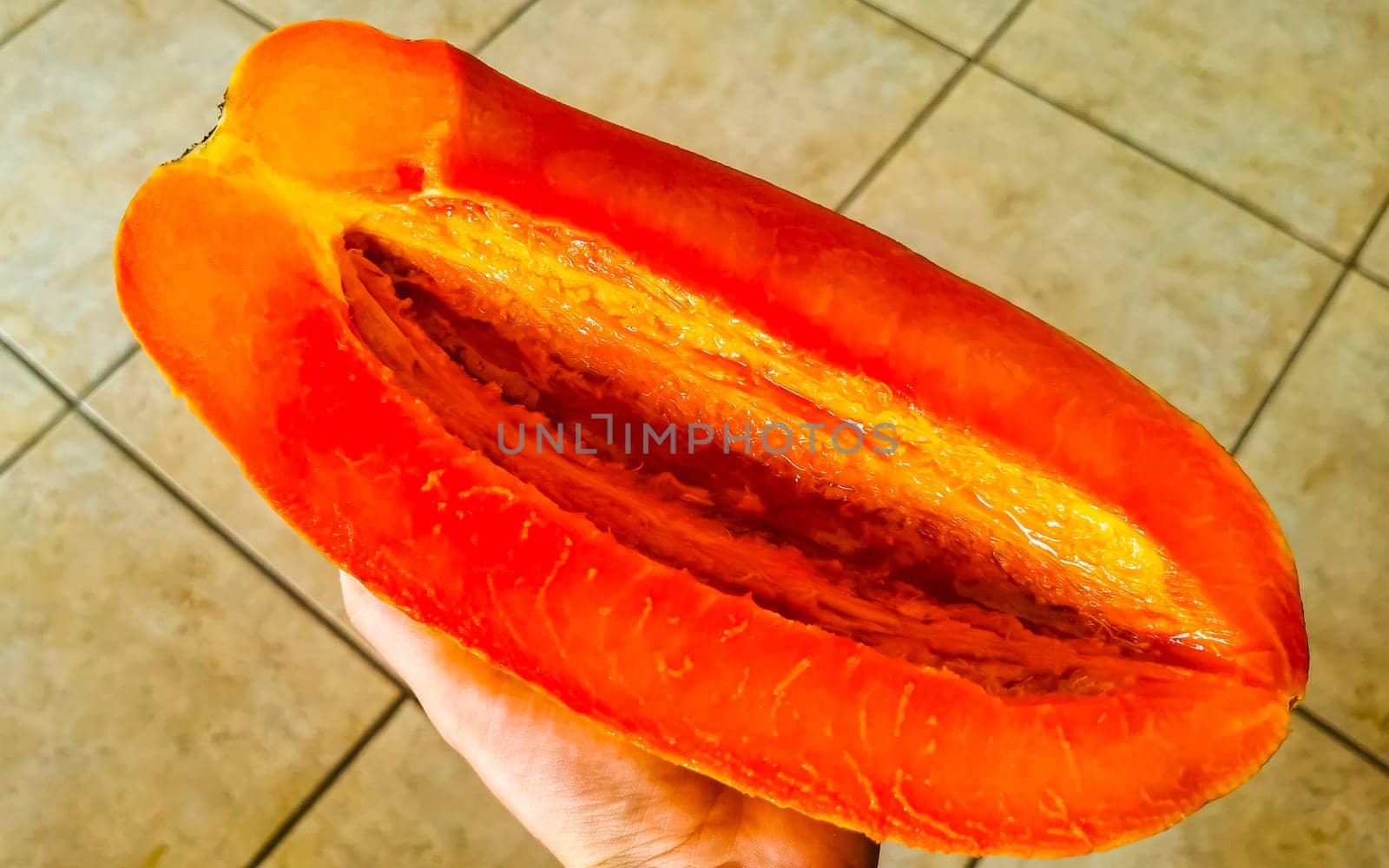Half papaya in hand with background in Playa del Carmen Quintana Roo Mexico.