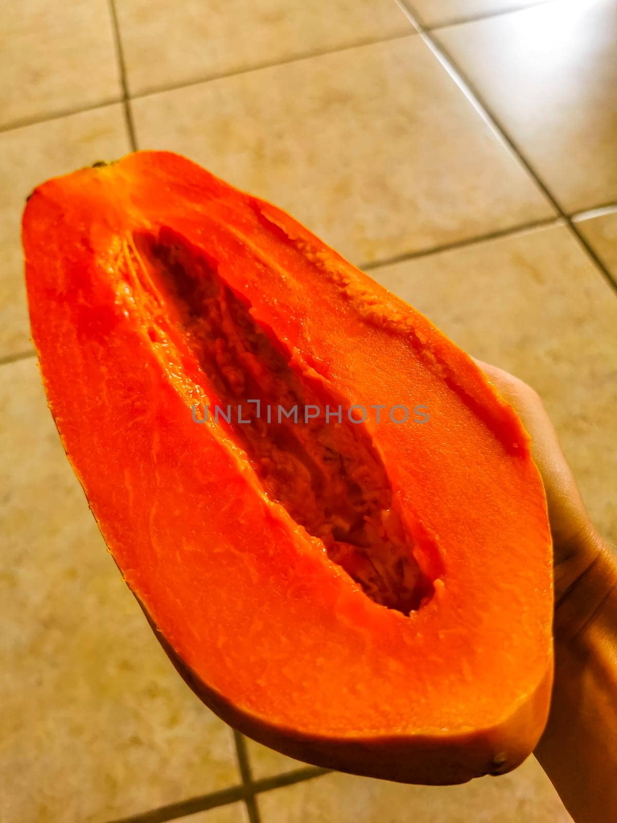 Half papaya in hand with background in Playa del Carmen Quintana Roo Mexico.