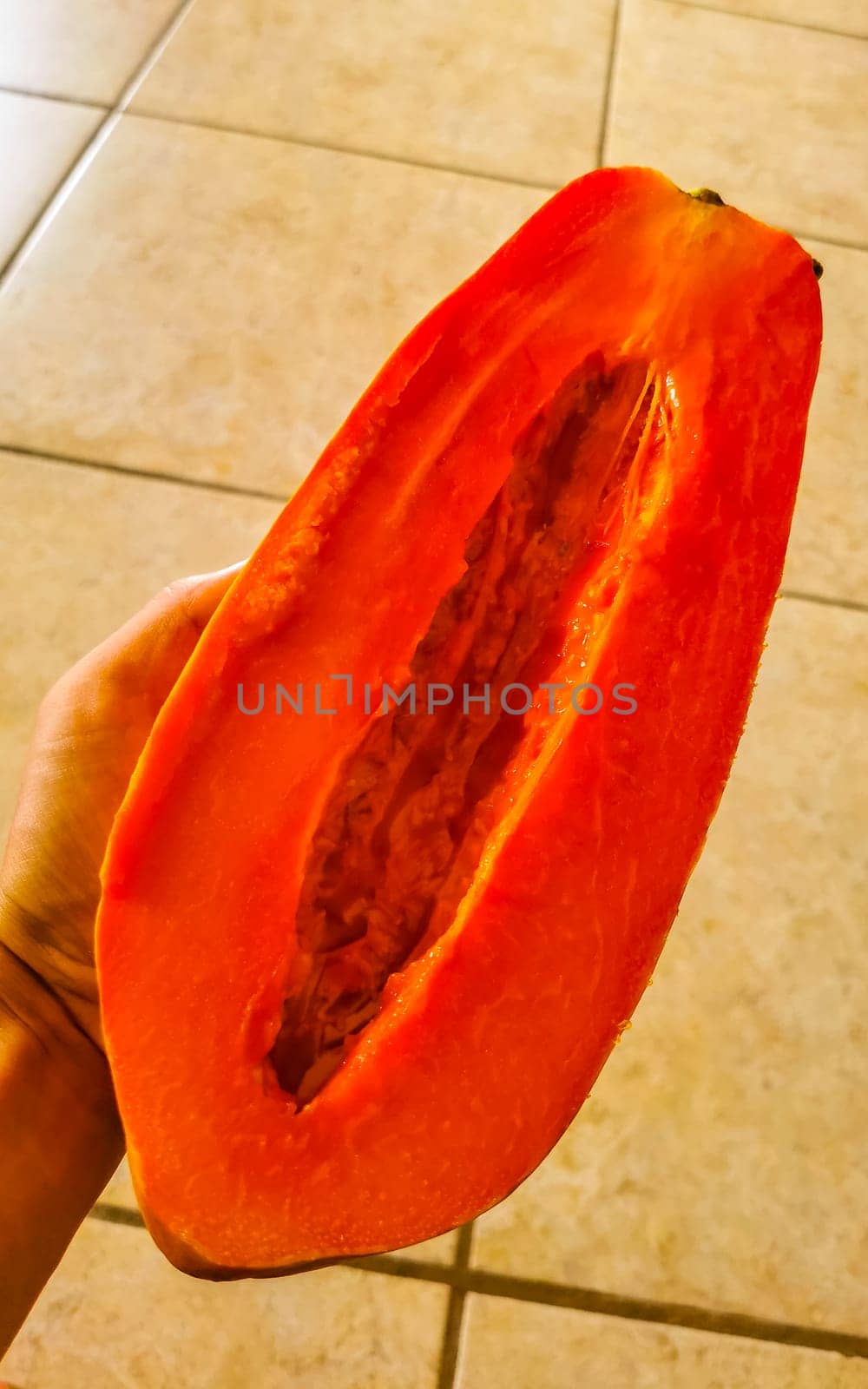 Half papaya in hand with background in Playa del Carmen Quintana Roo Mexico.