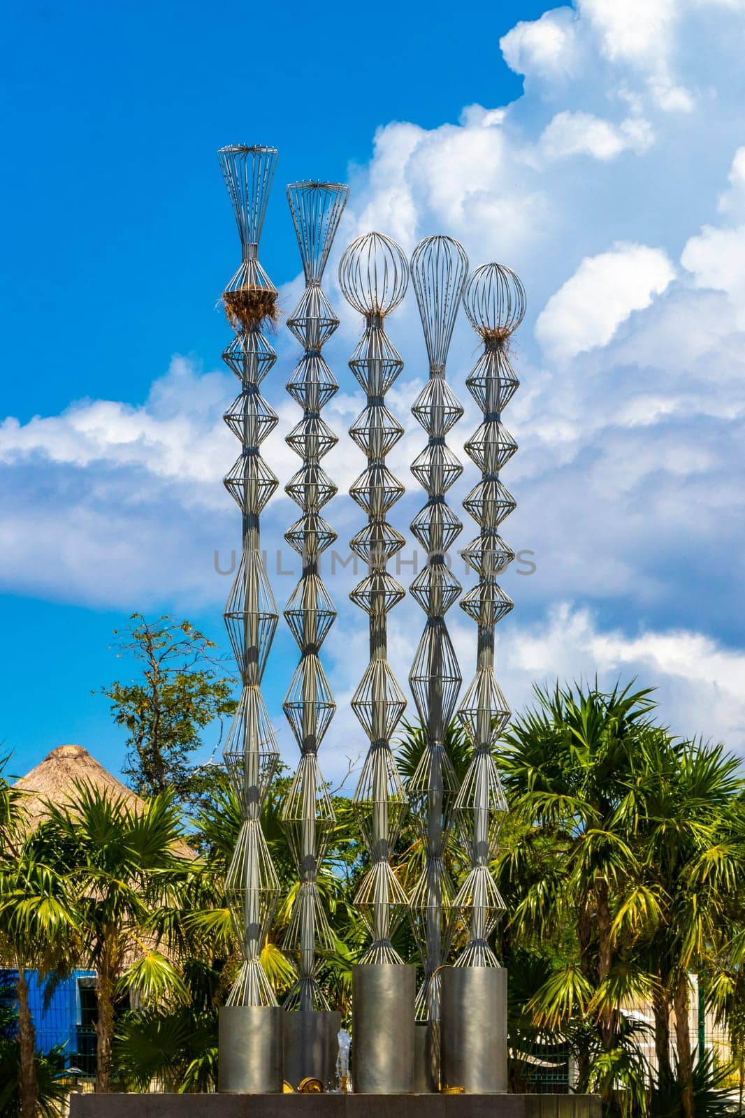 Artistic fountain well with metal figures in tropical setting Mexico. by Arkadij