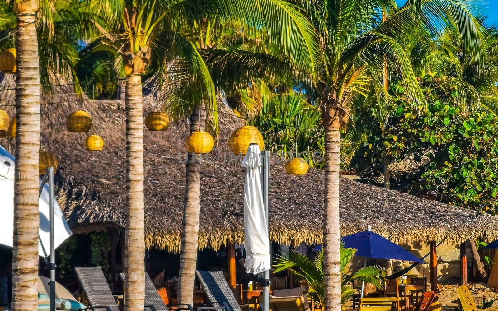 Restaurant hotel palm trees promenade bar on beach Puerto Escondido. by Arkadij