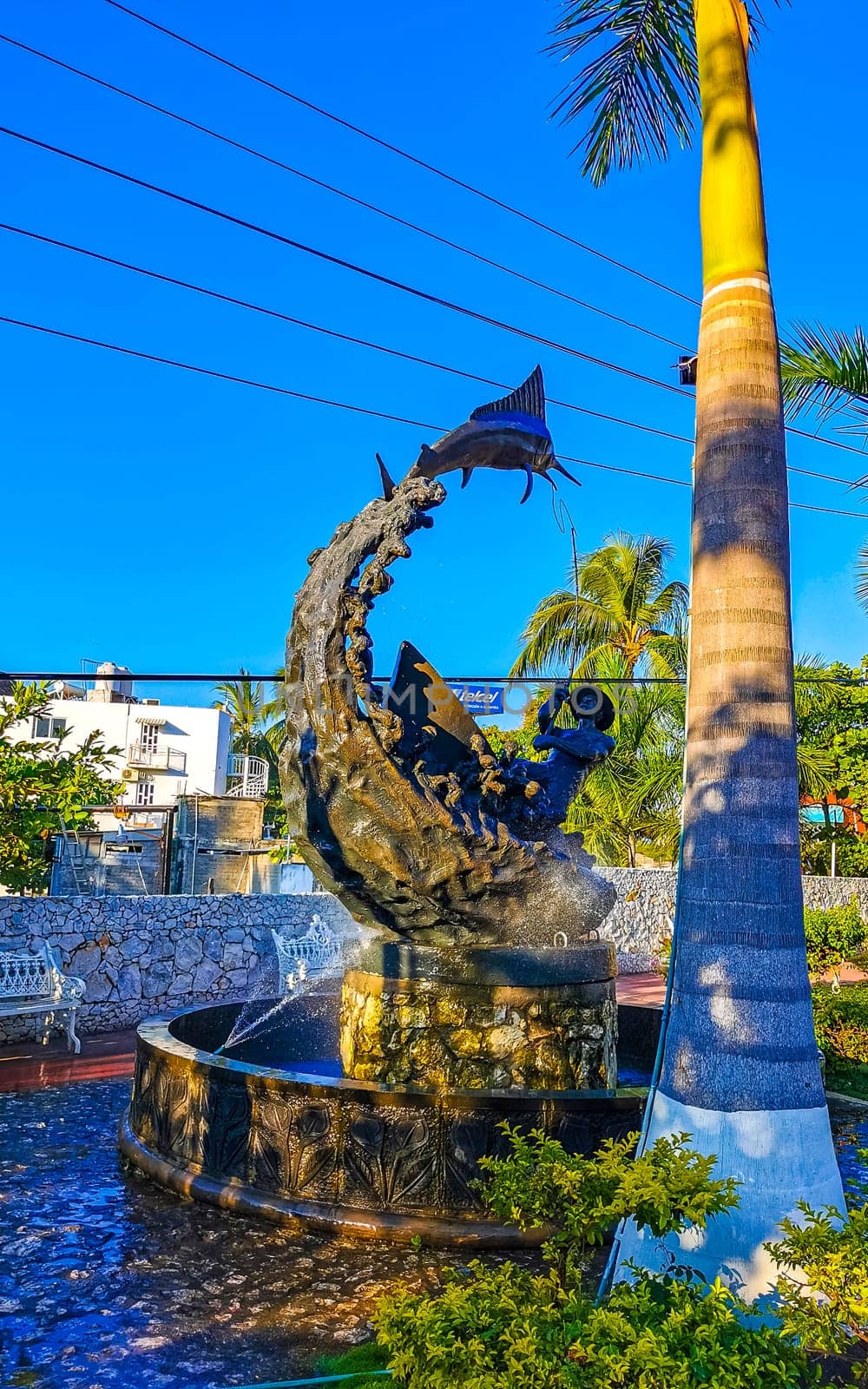 Statue sculpture angler with fish fountain in Puerto Escondido Mexico. by Arkadij