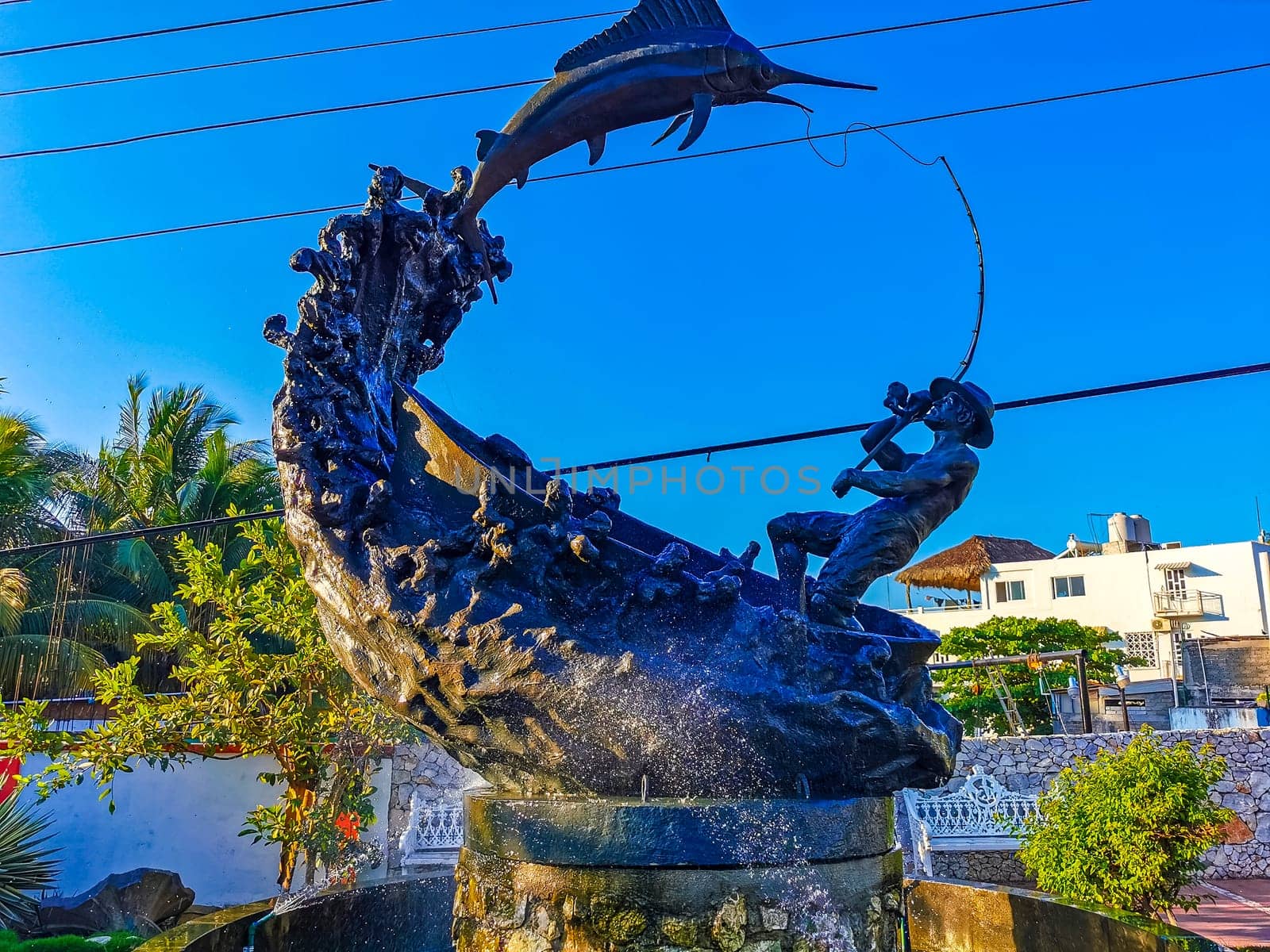 Statue sculpture angler with fish swordfish fountain in Zicatela Puerto Escondido Oaxaca Mexico.