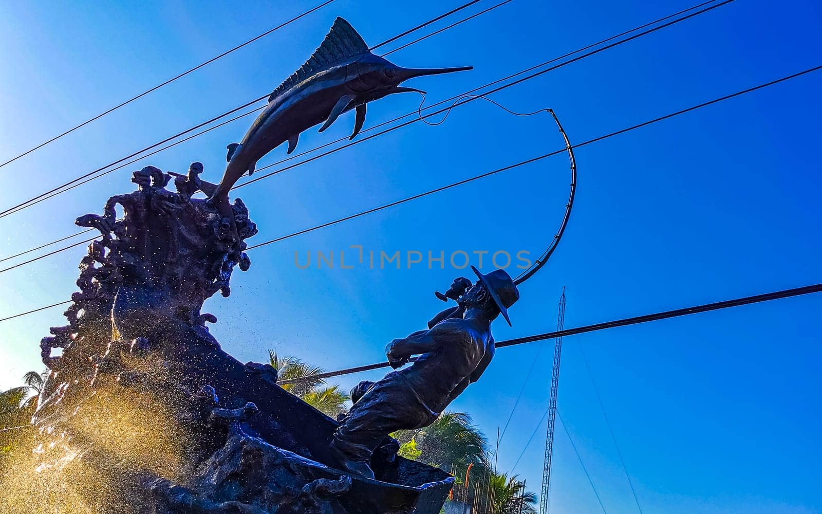 Statue sculpture angler with fish fountain in Puerto Escondido Mexico. by Arkadij