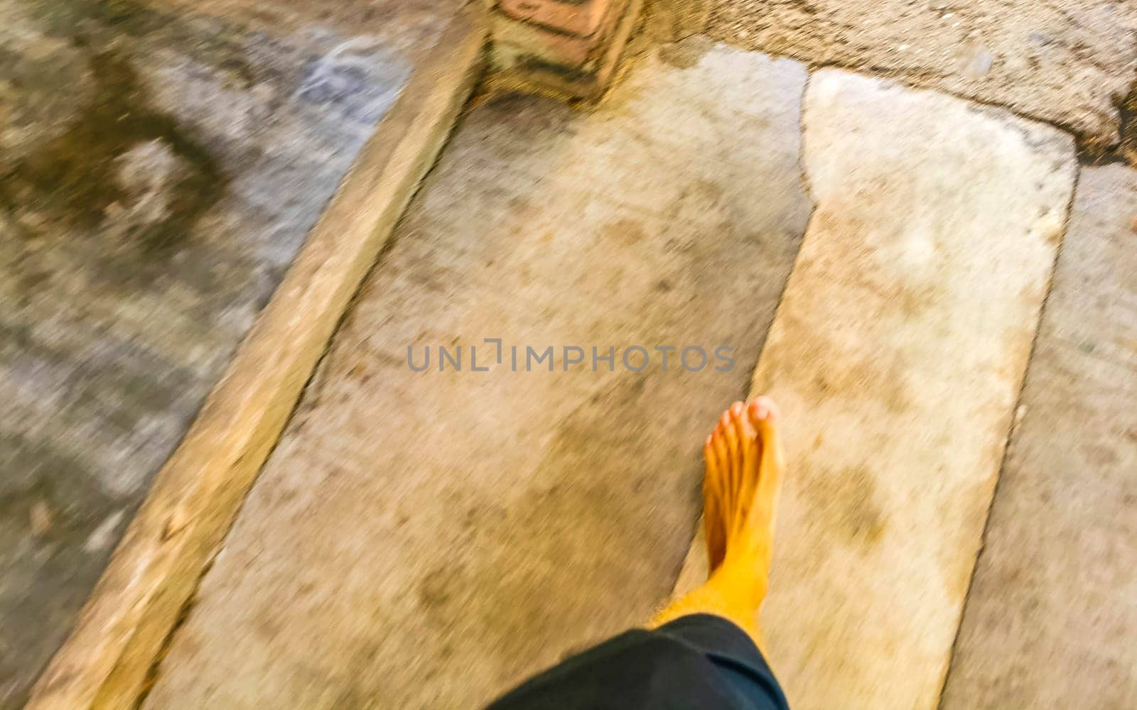 Walking on the pavement rocks stones feet barefoot in Mexico. by Arkadij