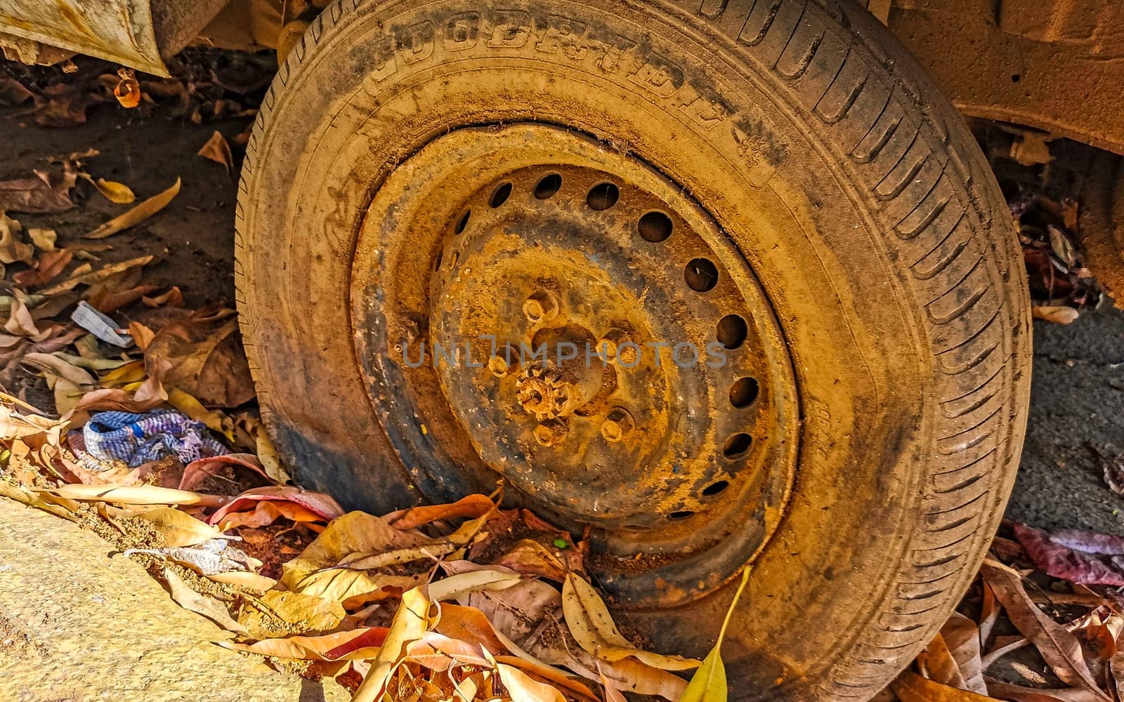 Flat rusted old tire on the car in Zicatela Puerto Escondido Oaxaca Mexico.
